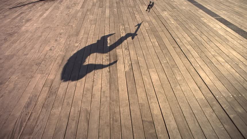 Person does a skateboard trick on a sunny day