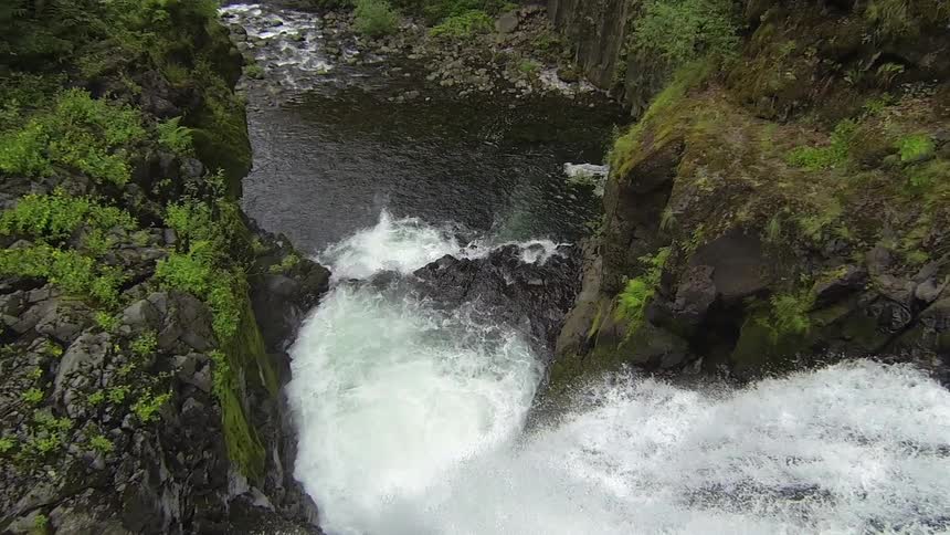 A waterfall cascading over rocks between steep cliffs