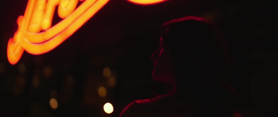 Person standing outside looking around at night