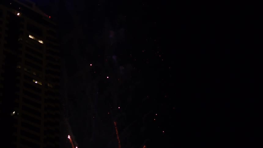 Fireworks exploding in the night sky in an urban area