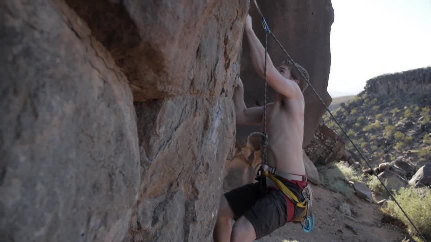 A man climbs up a rock