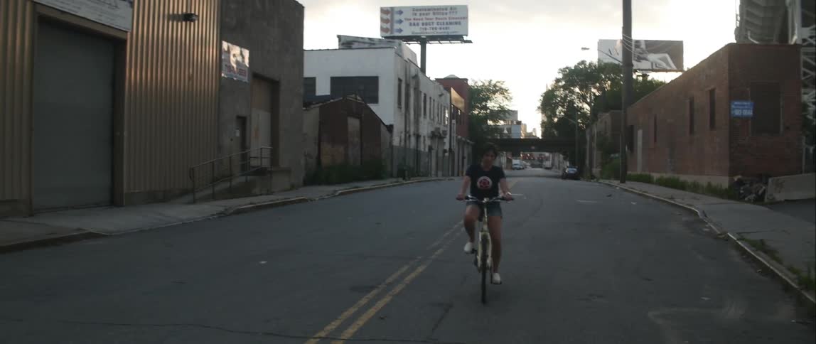 Woman rides her bike down an empty street