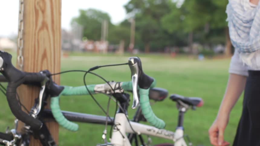 Woman parks her bike then walks off