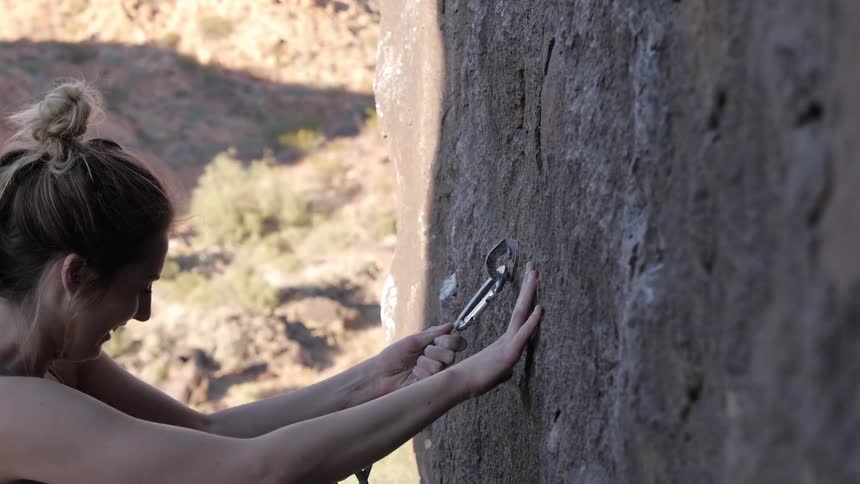 Woman laughs as she rock climbs