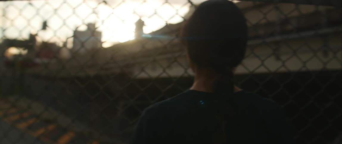A person standing in front of a fence