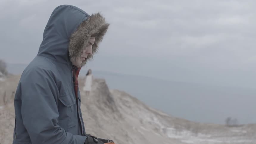 A man about to fire a flare gun as he spots a woman in the distance
