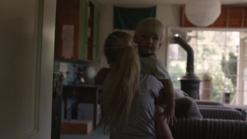 Girl picks up a child and walks into another room