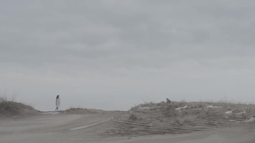 Someone running towards a woman in a white dress before they stumble and fall