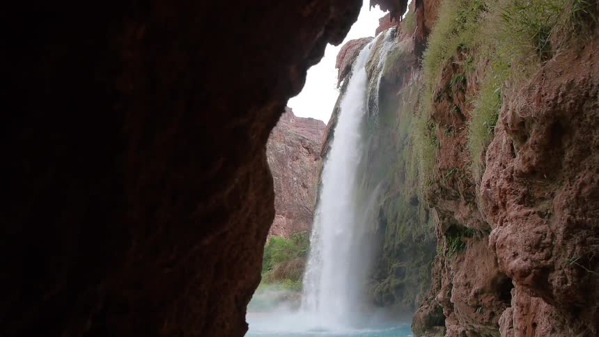 A waterfall gushes over a cliff