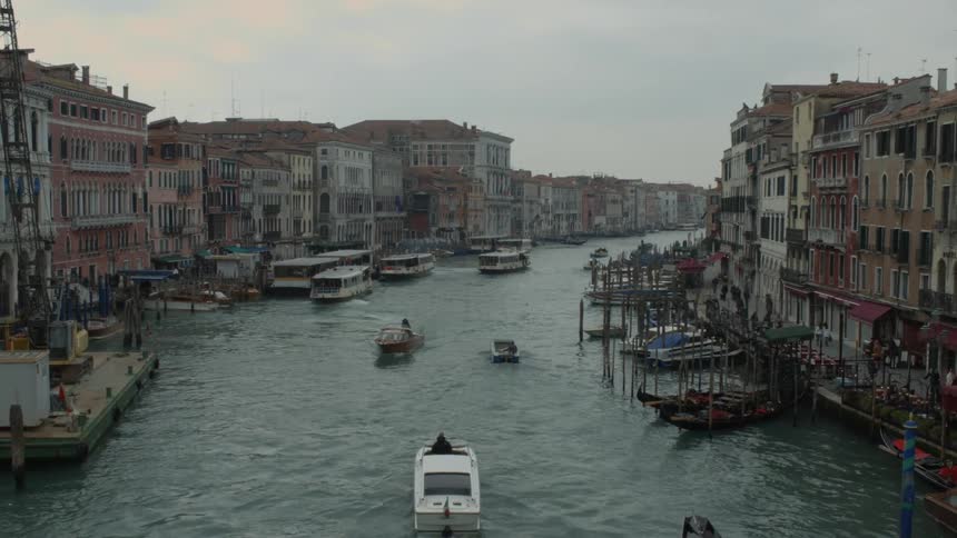 Boats traveling down a canal near a city