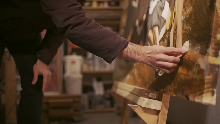 Person applying a substance to a wood project using a tool