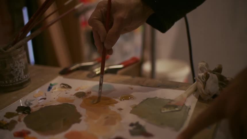 A man mixing paint colors