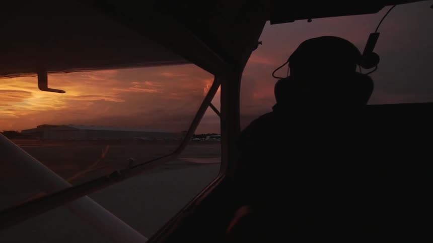 Pilot landing a plane at dusk