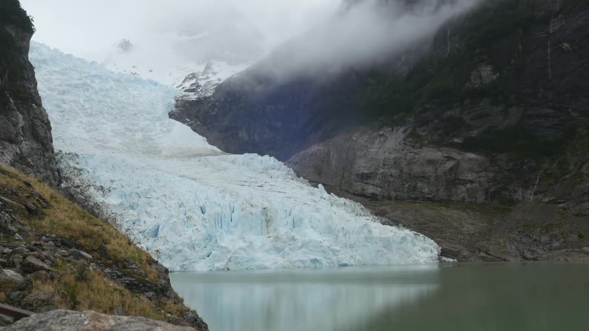 A glacier creeps into a lake