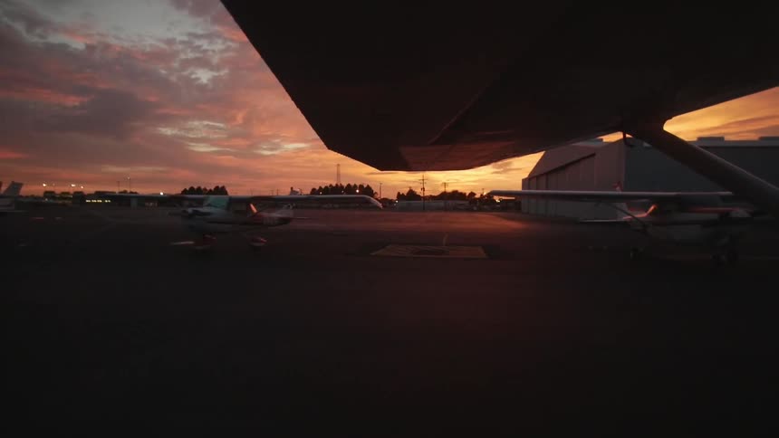 An airplane drives on an airport tarmac at dusk