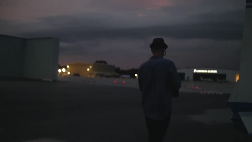 Man walking down a lot at sunset