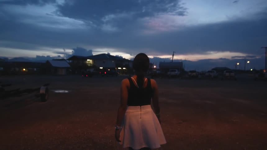 Woman in a white dress walking at sunset