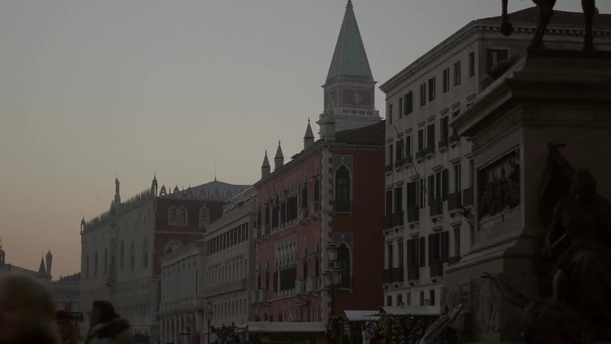 View of old buildings as people walk around