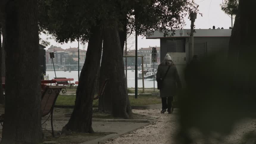 A woman walking down a path towards water