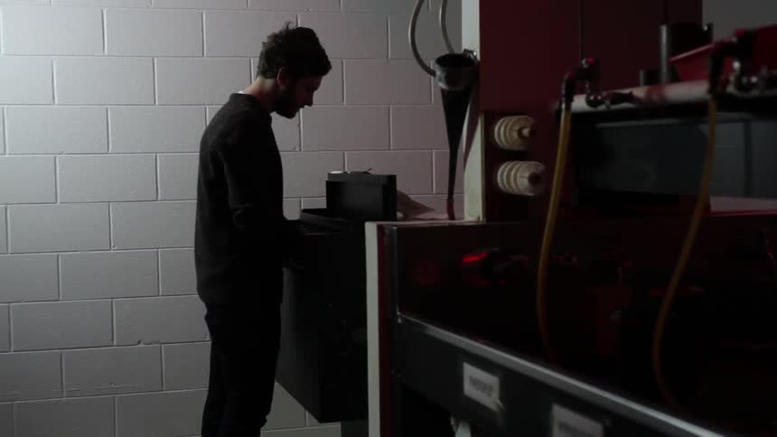 A man placing paper in a developing machine