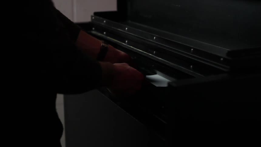 Man walks up to a machine and inserts something