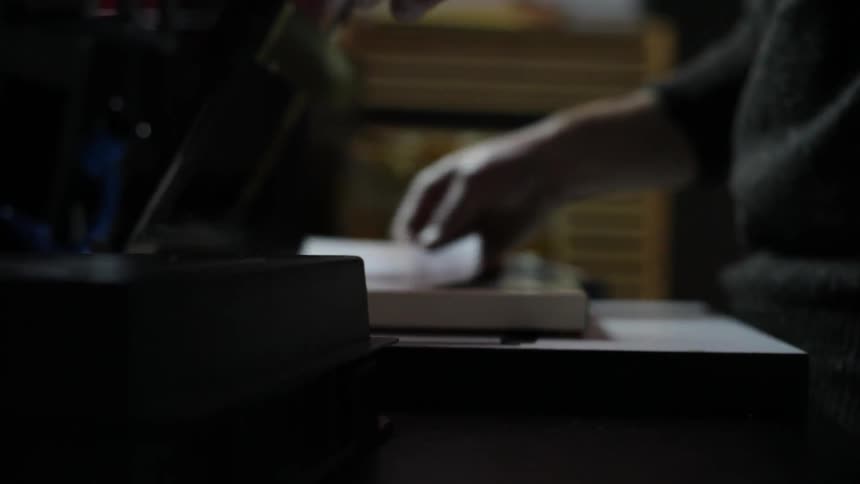 Man uses a machine to cut paper