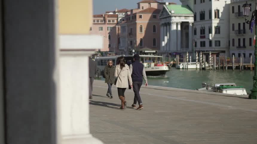 People walking beside a canal in town