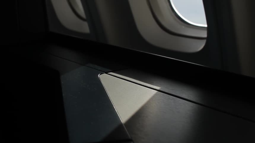 Sunlight comes through a small airplane window