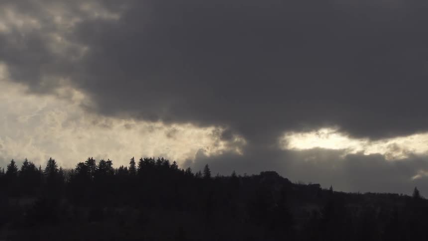 Heavy clouds over a forest at sunset