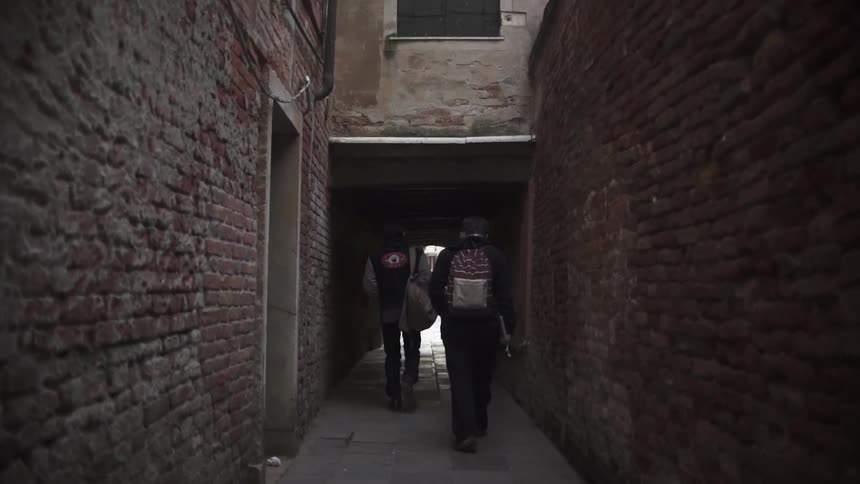 Two men walking down a small alley