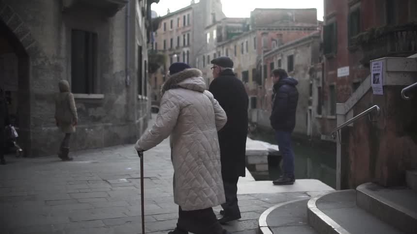People walking down a stone path in a town