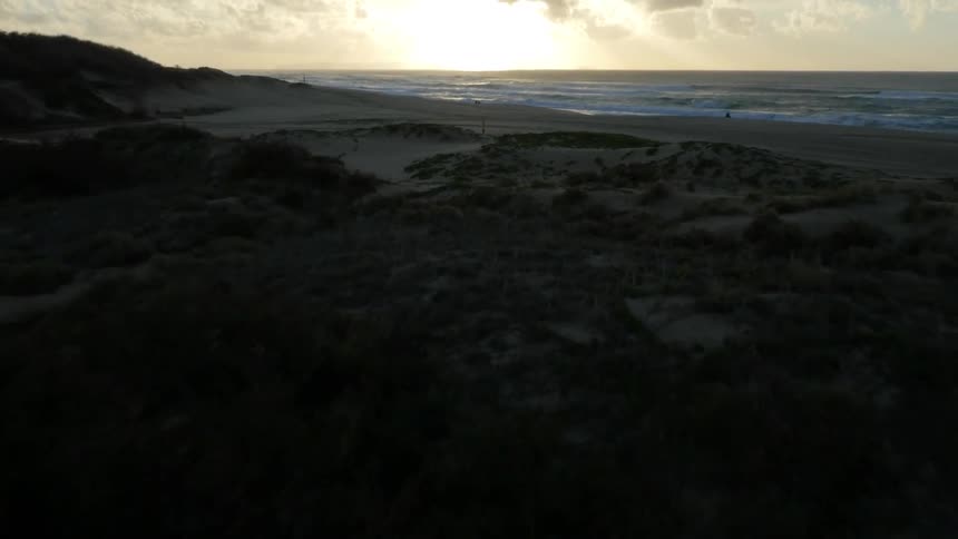 Fast pan away from an empty beach on a cloudy day