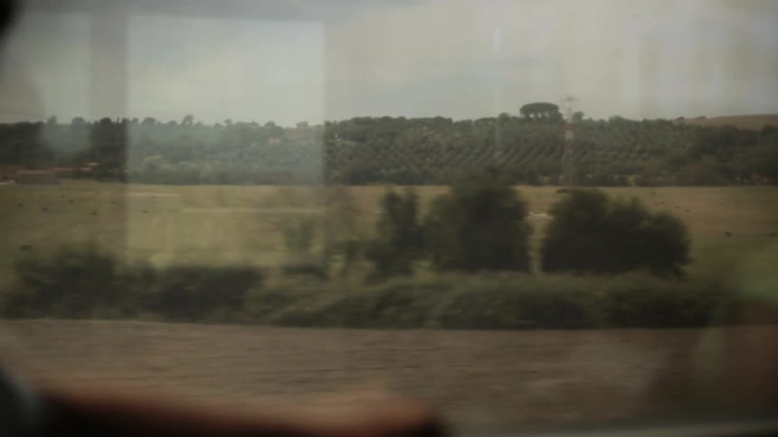 A passenger train rides through a rural area