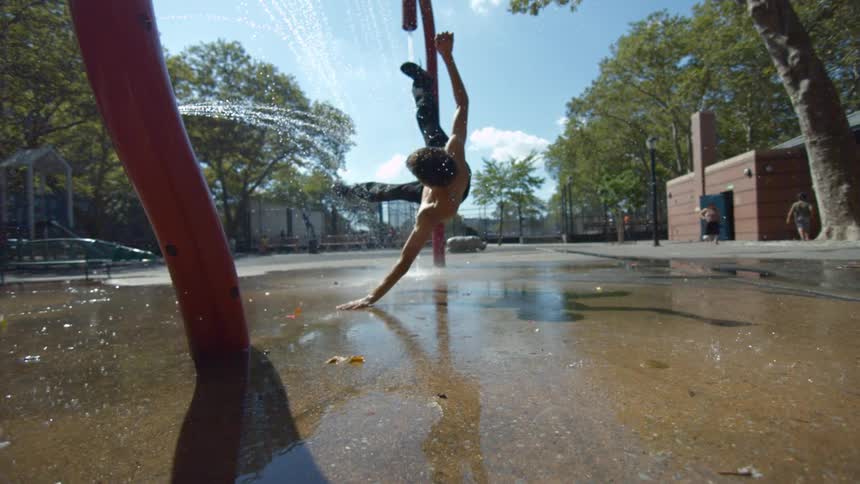 Young man falling under a sprinkler in slow motion