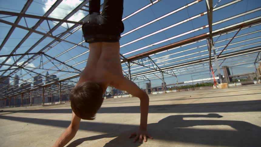 A boy is doing gymnastics in the park