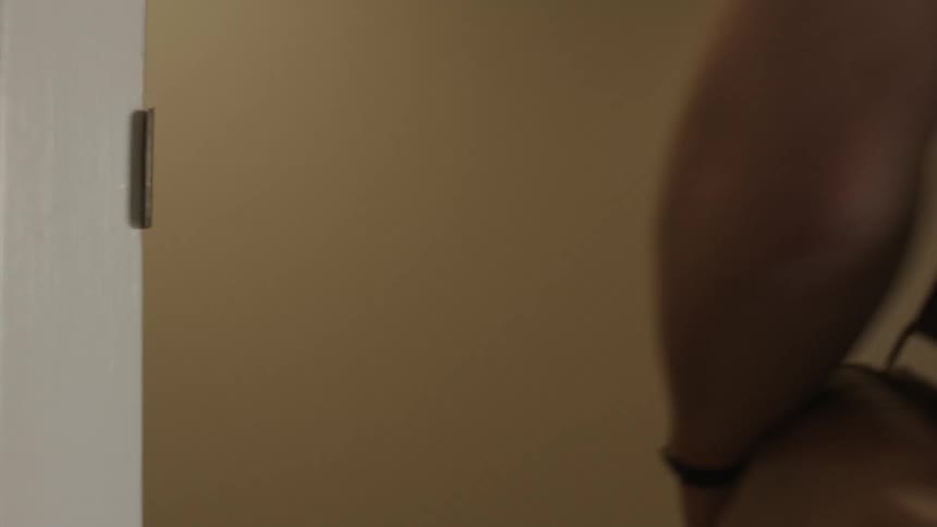 A person leaving a room and closing the door