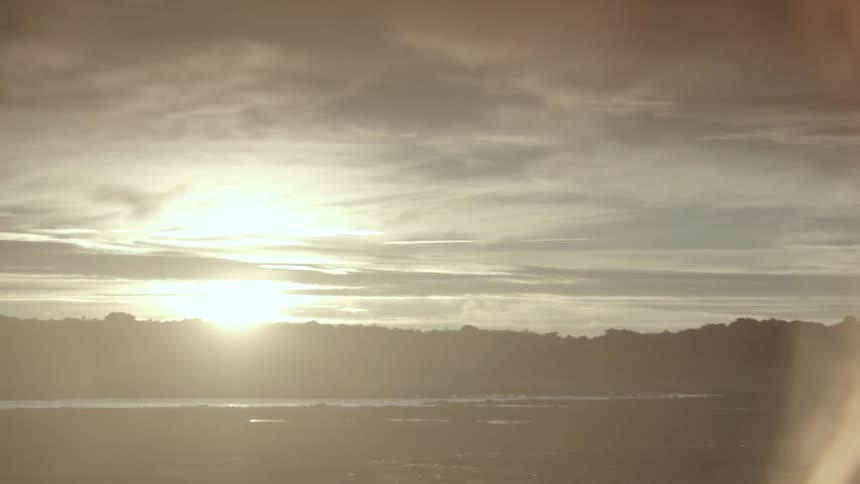 View of a cloudy sky over hills at sunrise