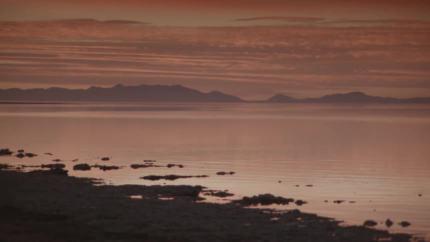 Sun is setting over a calm beach