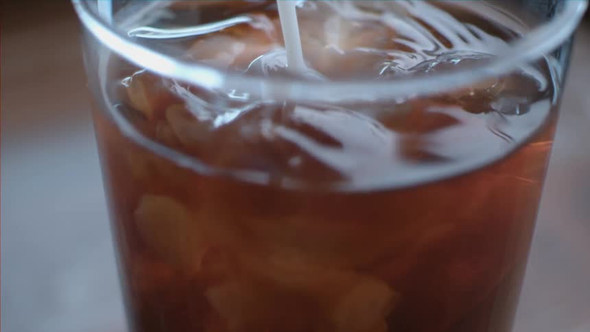 A glass of liquid with ice cubes