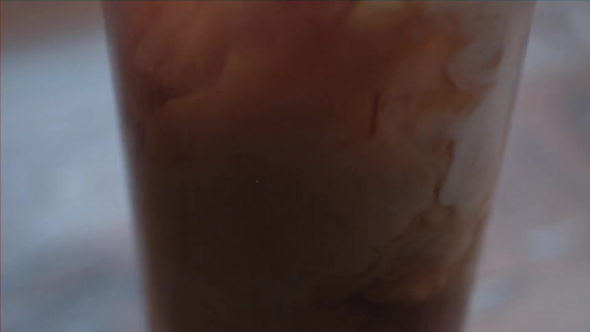 A glass of liquid with ice cubes