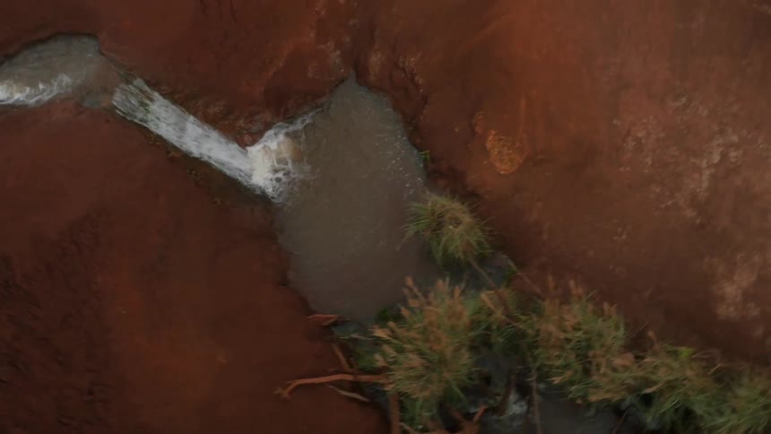 Water from a small stream flows through a rock formation