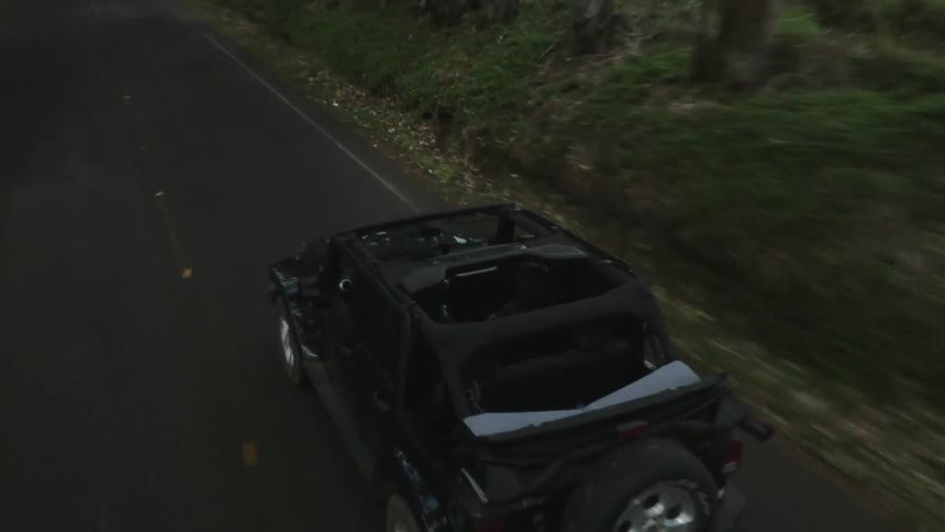 A jeep drives down a rural road