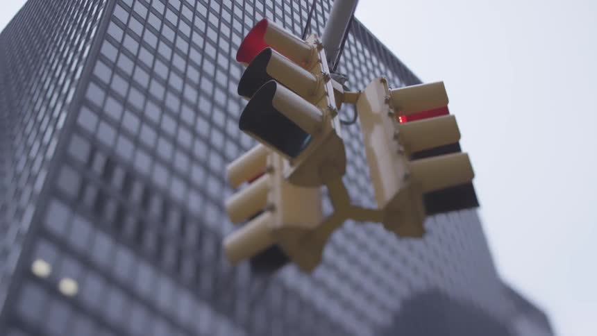 Three stop lights hanging from a street pole