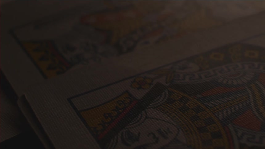 Dark view of some playing cards being laid down