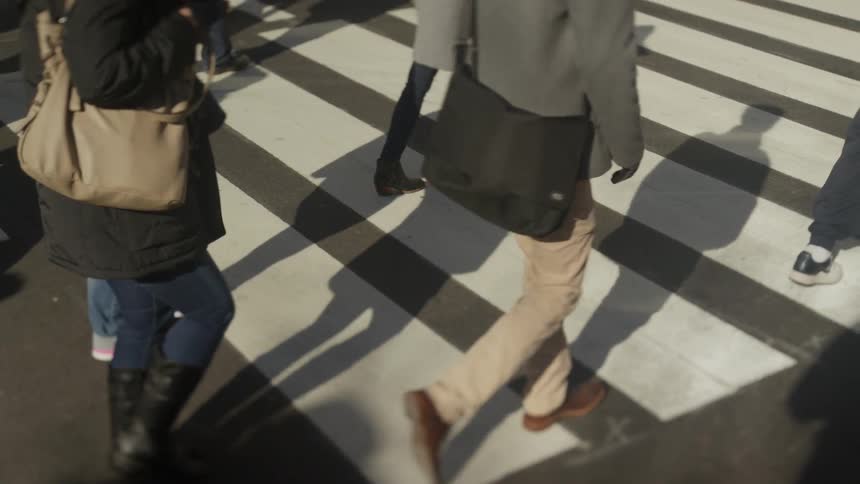 Group of people walk across a street crosswalk