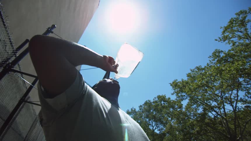 A man drinks water during the day