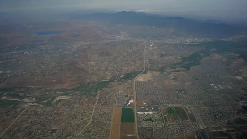 A plane flies over a town