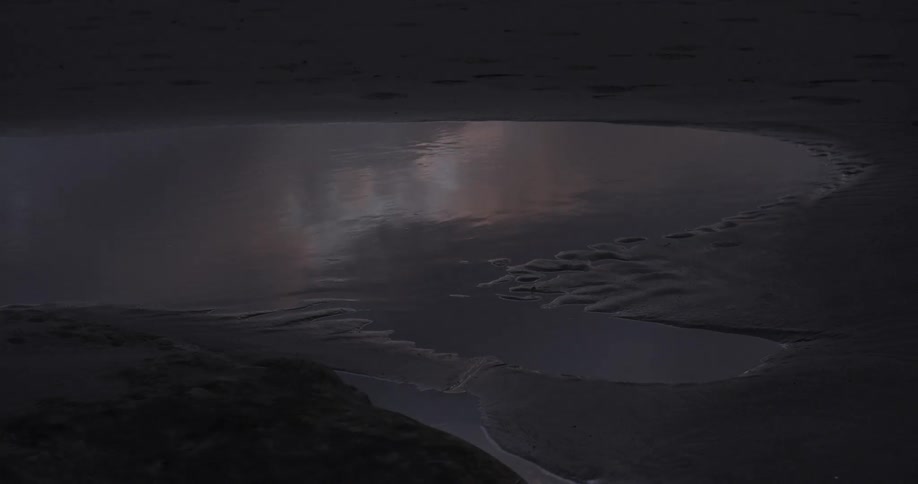 Light reflects off of a rippling puddle