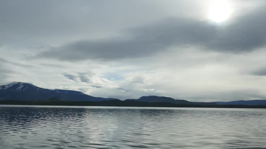 A lake stands quiet in the middle of the day