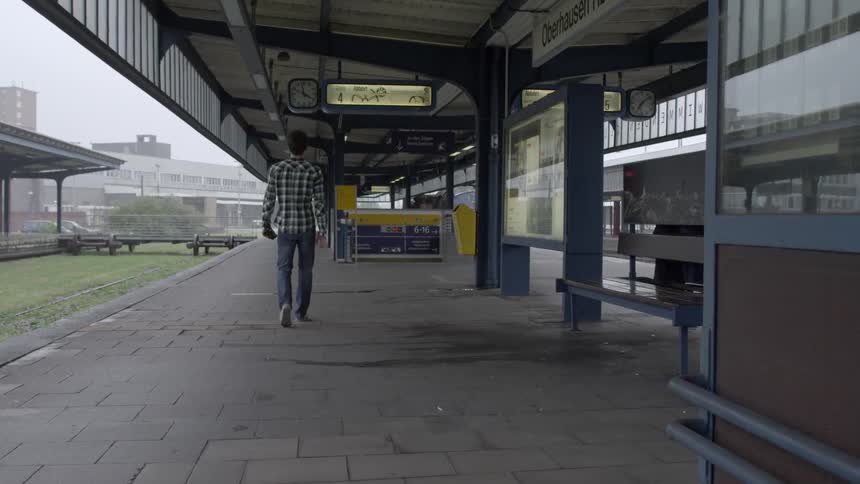 Man walking on a sidewalk outside a train station